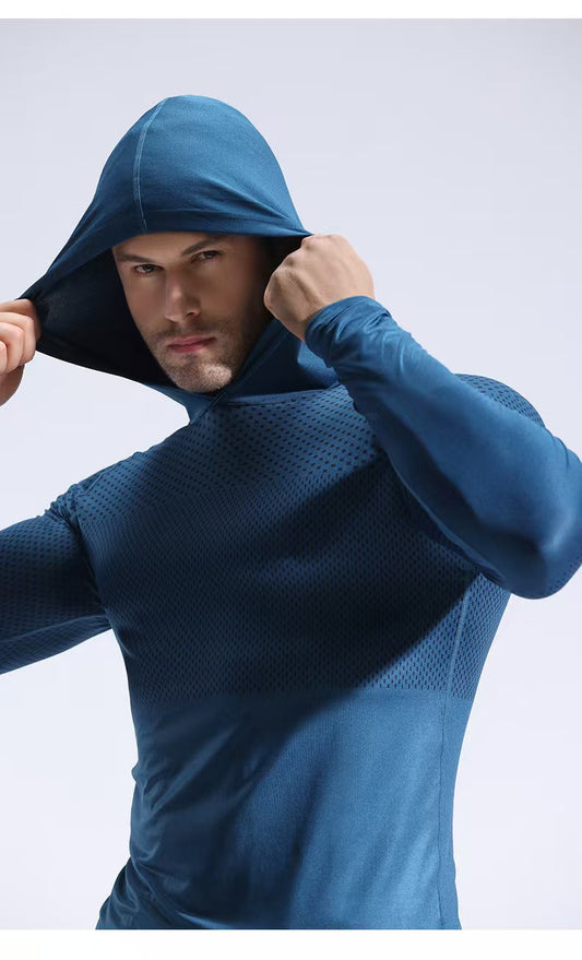 Man wearing a blue hooded top against a light gray background